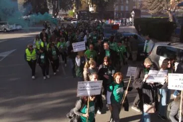Manifestantes con camisetas verdes y pancartas durante una huelga educativa.