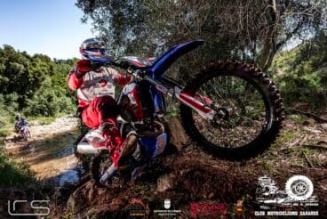 Fotografía de Cristóbal Cholbi montando su motocicleta de enduro por un terreno rocoso y empinado durante una competición.