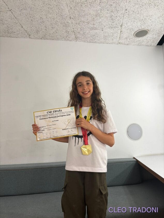 Imagen: Cleo Tradoni sonríe sosteniendo su diploma y medalla del primer premio en el Concurso Nacional CND España Cartagena 2026.