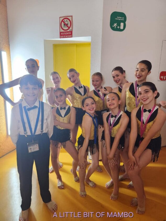 Imagen: Grupo de jóvenes bailarines de la escuela Endanza posando con trajes de competición y medallas tras su actuación.