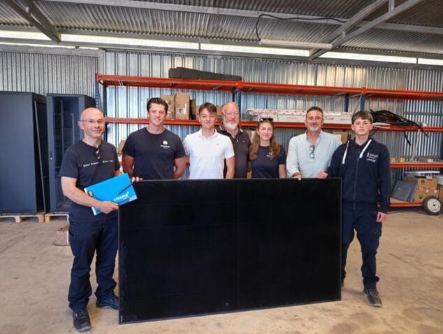 Bild: Stadtrat Juanlu Cardona, Lehrer und Schüler von Creama Xàbia posieren mit einem Solarpanel in einem Lagerhaus von Redwood Solar.