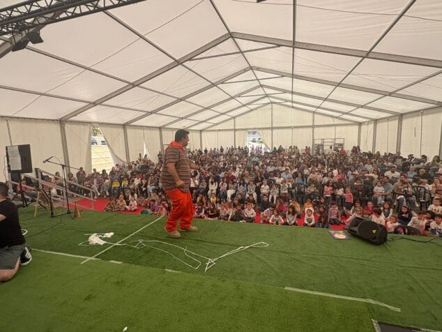 Paco Cholbi en el escenario presentando el espectáculo del Monstruo Petorro ante una carpa llena de público.