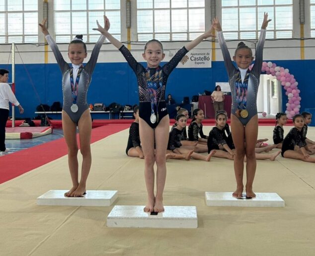 Tres jóvenes gimnastas con medallas en un podio durante la competición provincial en Castellón.