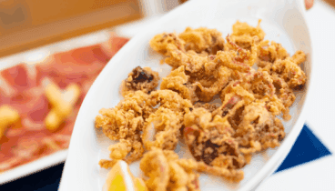 Variedad de tapas típicas mediterráneas servidas en la terraza del restaurante Mavita en el centro