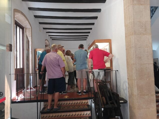 Imagen: Grupo de personas en una visita guiada mirando vitrinas en el interior del Museu Soler Blasco con techo de vigas de madera.