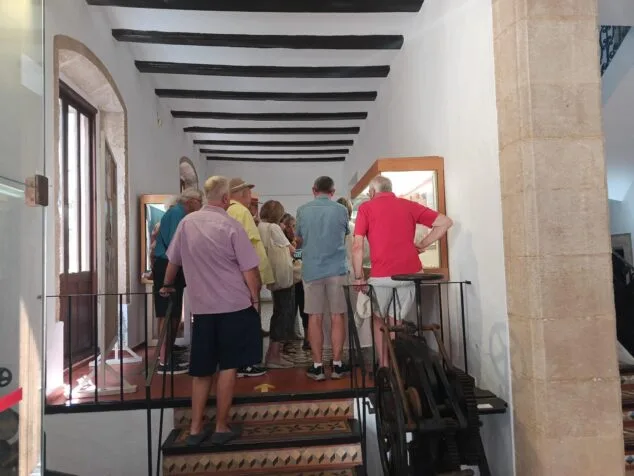 Imagen: Grupo de personas en una visita guiada mirando vitrinas en el interior del Museu Soler Blasco con techo de vigas de madera.