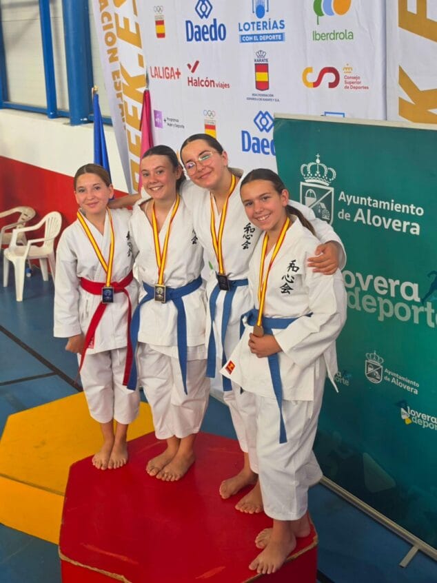 Imagen: Cuatro jóvenes competidoras de karate del Club Washinkai posan sonrientes en un podio con sus medallas en Alovera.