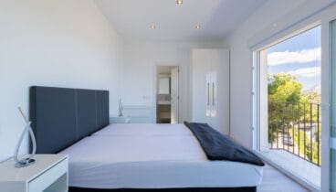 Dormitorio doble con armarios empotrados de madera noble y luz natural