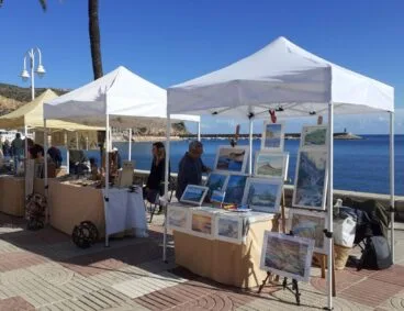 Puestos de la feria de artesanía de verano en el paseo marítimo del puerto de Jávea.