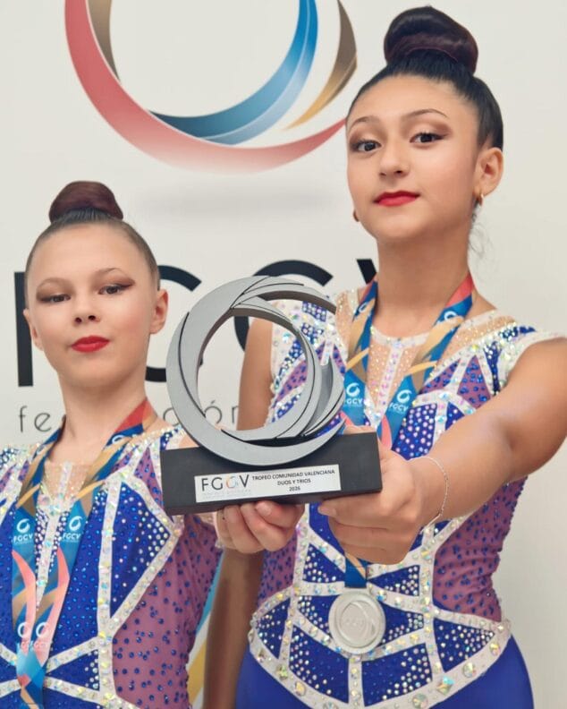 Imagen: Dos gimnastas del CD Montgó Xàbia sostienen un trofeo y llevan medallas tras su éxito en el campeonato autonómico.