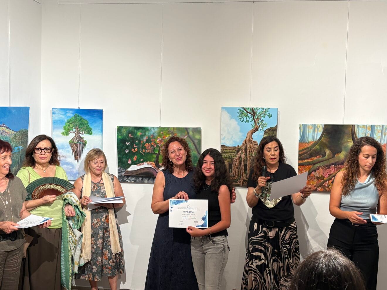 Una alumna recoge el diploma de fin de curso de pintura