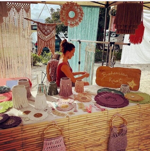Imagen: Artesana elaborando una pieza de macramé en su puesto del mercado.