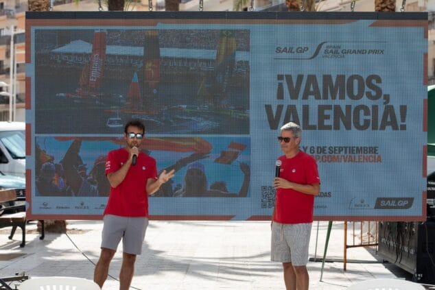 Imagen: Álvaro del Arco y Nico Abad con micrófonos en un escenario de SailGP en Xàbia ante una pantalla gigante promocional de Valencia.