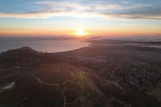 Fotografía de un amanecer con el sol saliendo sobre el mar y el macizo montañoso del Parque Natural del Montgó en primer plano.