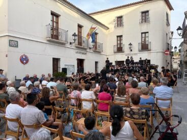 Concierto al aire libre de la Orquesta Sinfónica de Xàbia en la Plaza Mayor de Benimantell llena de público.