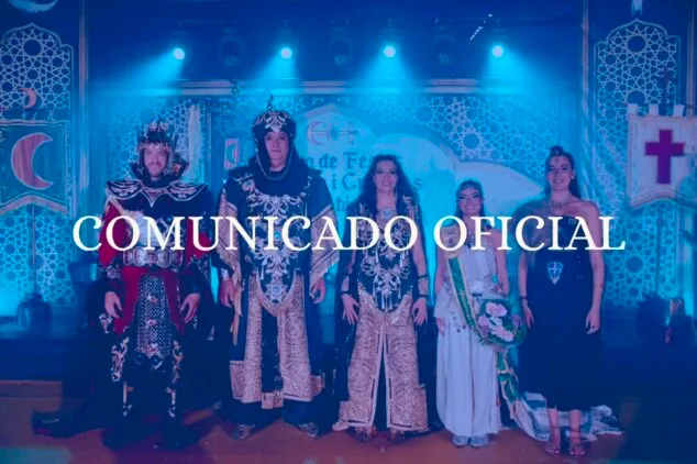 Imagen: Representantes de la Junta de Festes de Moros i Cristians de Xàbia con trajes festeros en un escenario con el texto "COMUNICADO OFICIAL" superpuesto.