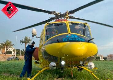 Helicóptero amarillo de los Bomberos de la Diputación de Alicante en tierra con personal.