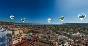 Vista aérea panorámica de la costa y el casco urbano de Xàbia con iconos de localización.