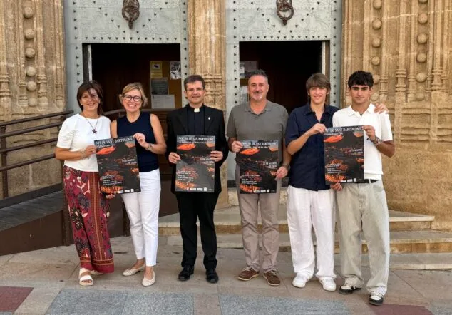 Imagen: La alcaldesa de Xàbia, el párroco y varios organizadores posan con el cartel de la Nit de Sant Bartolomé frente a la iglesia.