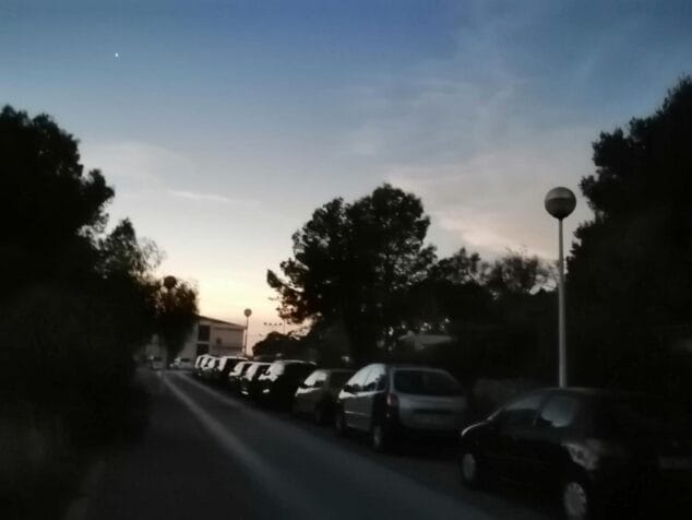 Imagen: Calle del centro de Xàbia con coches aparcados y sin gente al atardecer durante el eclipse.