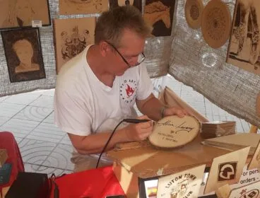 Artesano pirograbador trabajando en la feria de Jávea