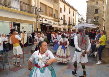 Participantes ataviados con indumentaria tradicional durante una exhibición de danzas populares en las calles del centro histórico de Xàbia