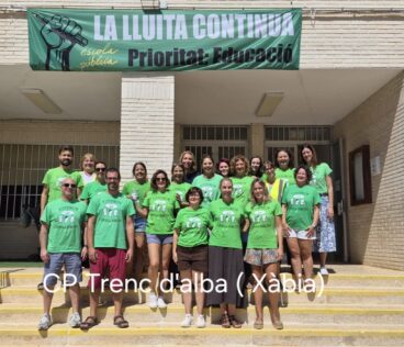 Profesorado del CP Trenc d'Alba de Xàbia concentrado con camisetas verdes y una pancarta que dice "LA LLUITA CONTINUA escola pública Prioritat: Educació".