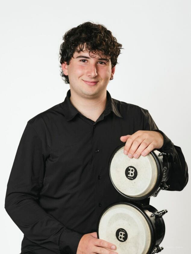 Retrato del joven percusionista Joan Salort sosteniendo unos bongós.