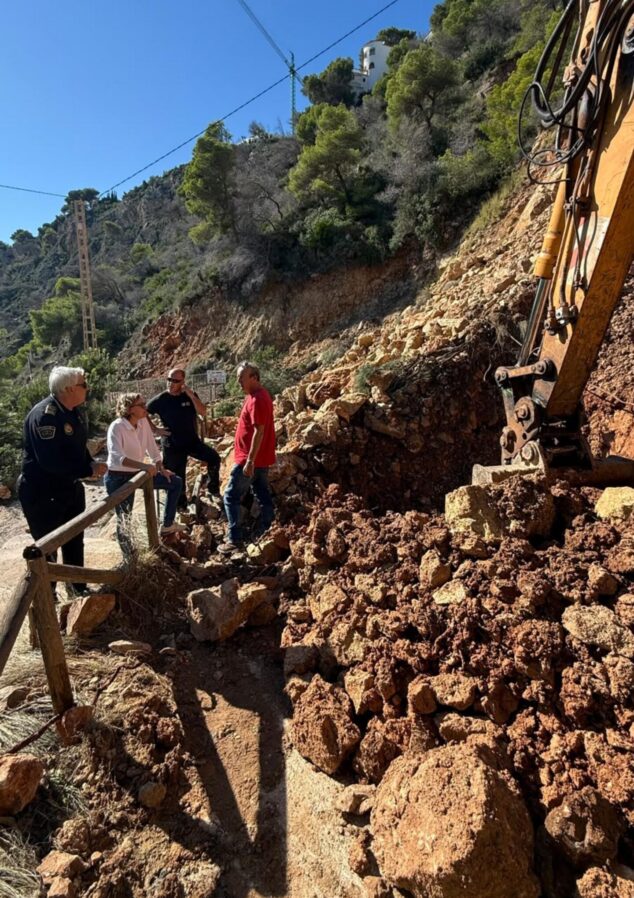 Imagen: Varios técnicos y responsables observan a una excavadora retirando un gran montículo de tierra y rocas tras un desprendimiento en una zona de montaña de Xàbia.